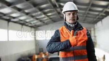 戴着安全帽、穿着工作服的胡子和胡子正站在机库中间，竖起大拇指